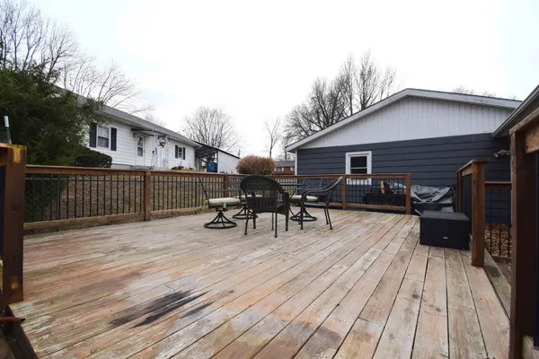 a view of a roof deck with table and chairs wooden floor and fence