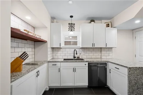 a kitchen with a sink dishwasher and cabinets