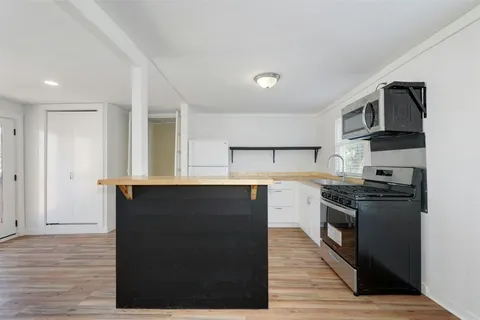 a kitchen with stainless steel appliances granite countertop a stove a sink and a refrigerator