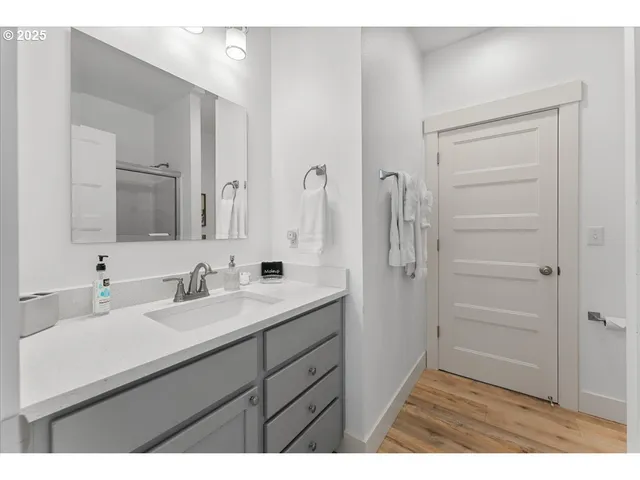 a bathroom with a sink a mirror a vanity and a shower