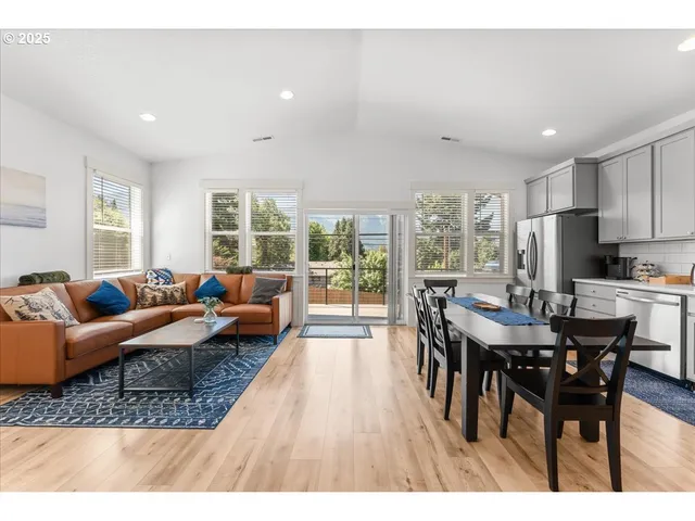 a living room with furniture dining table and a large window
