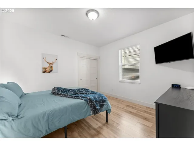 a bedroom with a large bed and a flat screen tv