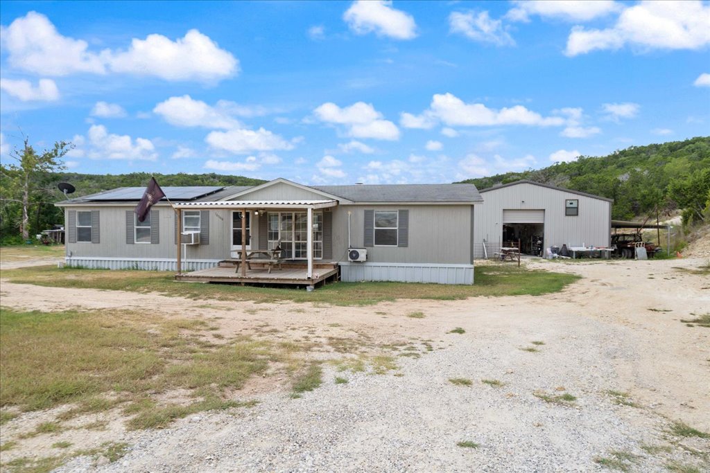 10500 Tarantula Court Leander, TX 78641 - Photo 3 of 34 a front view of a house with a dirt yard and a garage