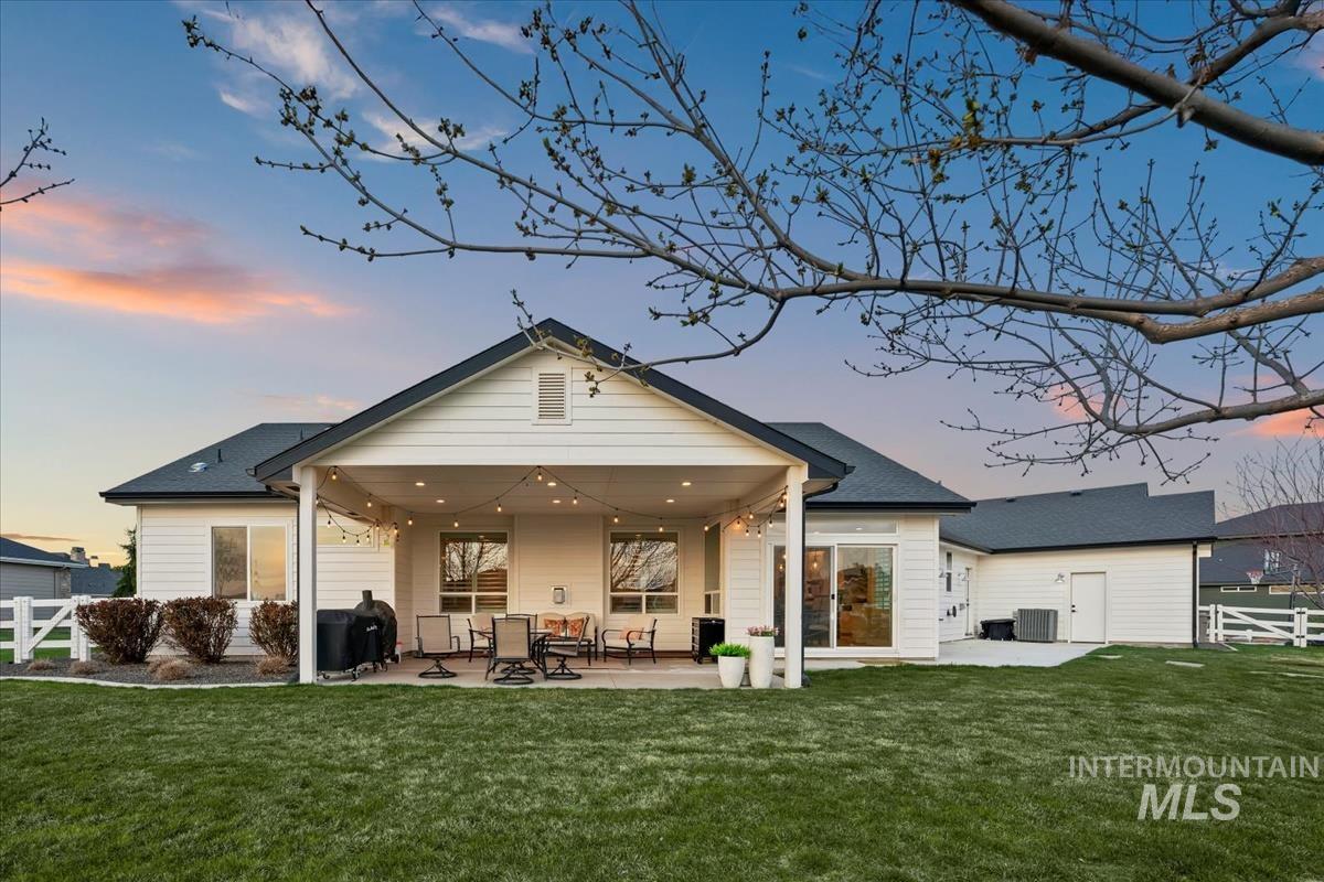 15111 Pinehurst Way Caldwell, ID 83607 - Photo 33 of 43 Back of house at dusk with a patio area