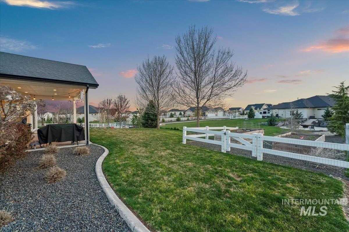 15111 Pinehurst Way Caldwell, ID 83607 - Photo 37 of 43 Yard at dusk featuring a fenced backyard, a residential view, and a patio