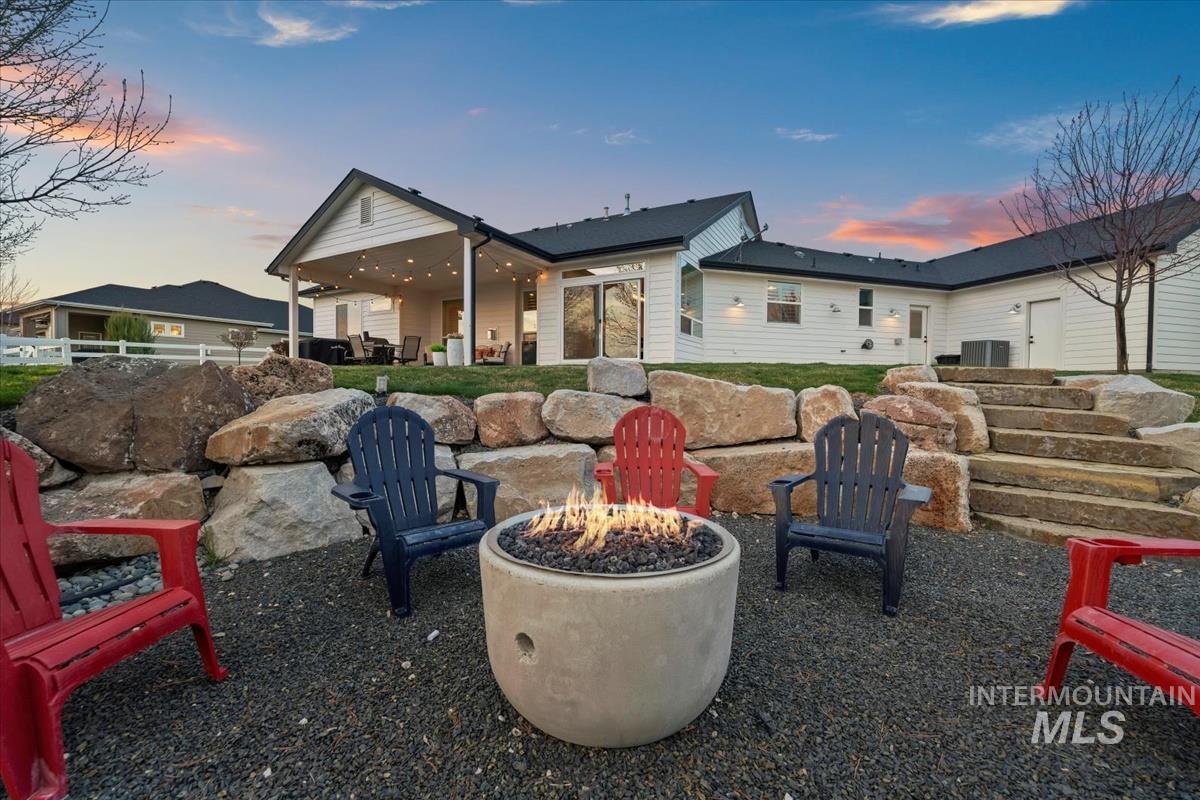 15111 Pinehurst Way Caldwell, ID 83607 - Photo 39 of 43 Back of property at dusk with a patio area and an outdoor fire pit