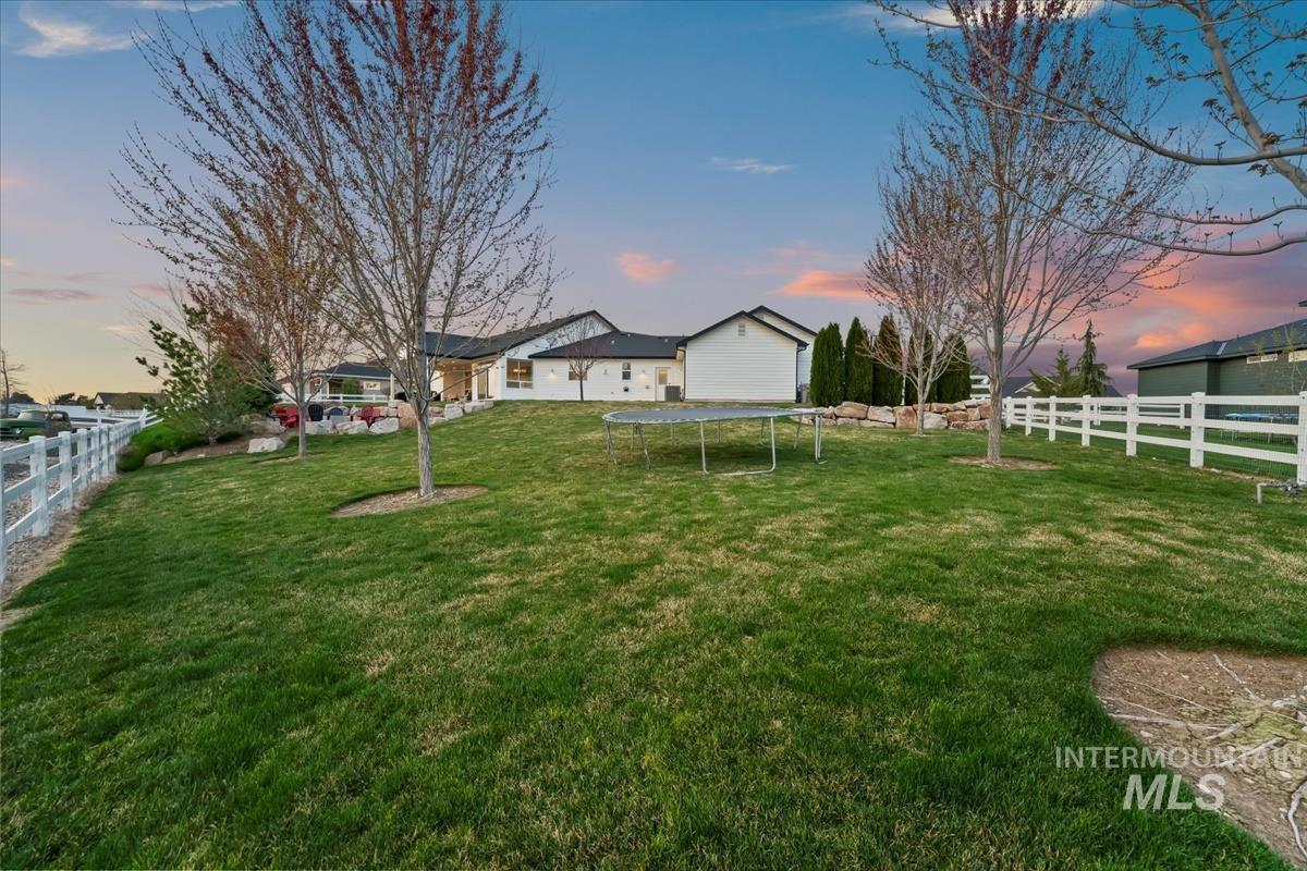 15111 Pinehurst Way Caldwell, ID 83607 - Photo 41 of 43 Yard at dusk featuring a fenced backyard and a trampoline