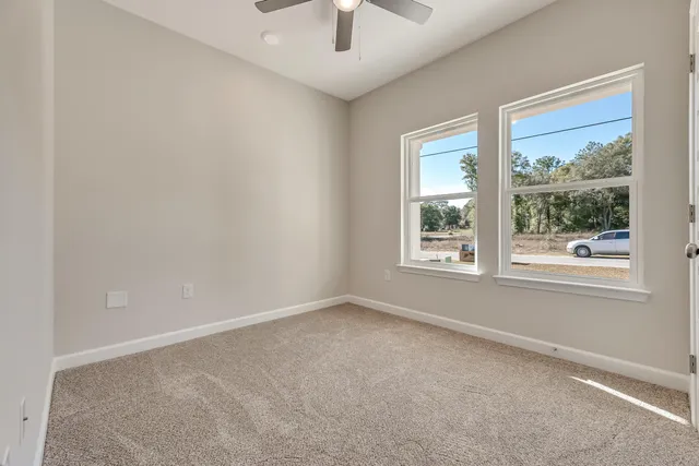 an empty room with a window and a fan