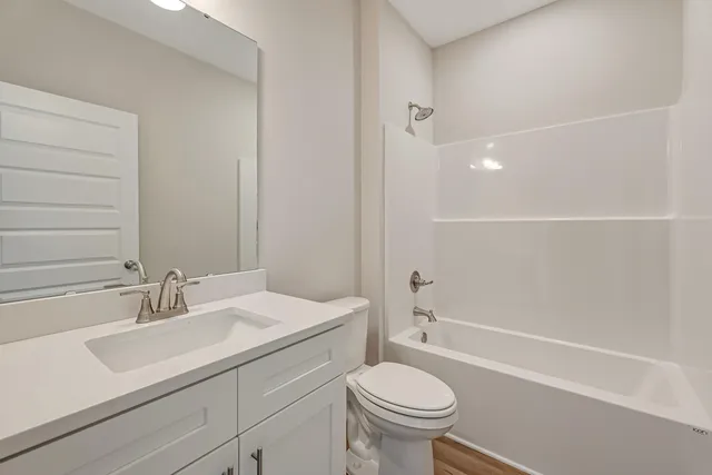 a bathroom with a sink toilet vanity and shower