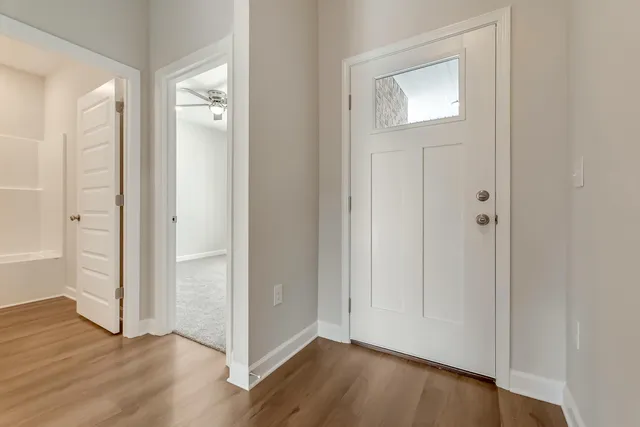 an empty room with wooden floor & closet area