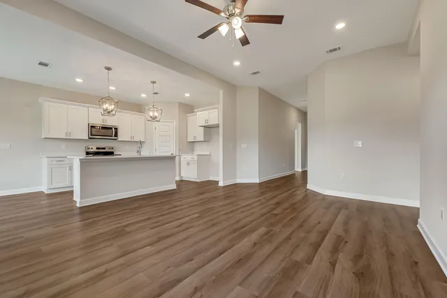 a view of kitchen with cabinets wooden floor and stainless steel appliances