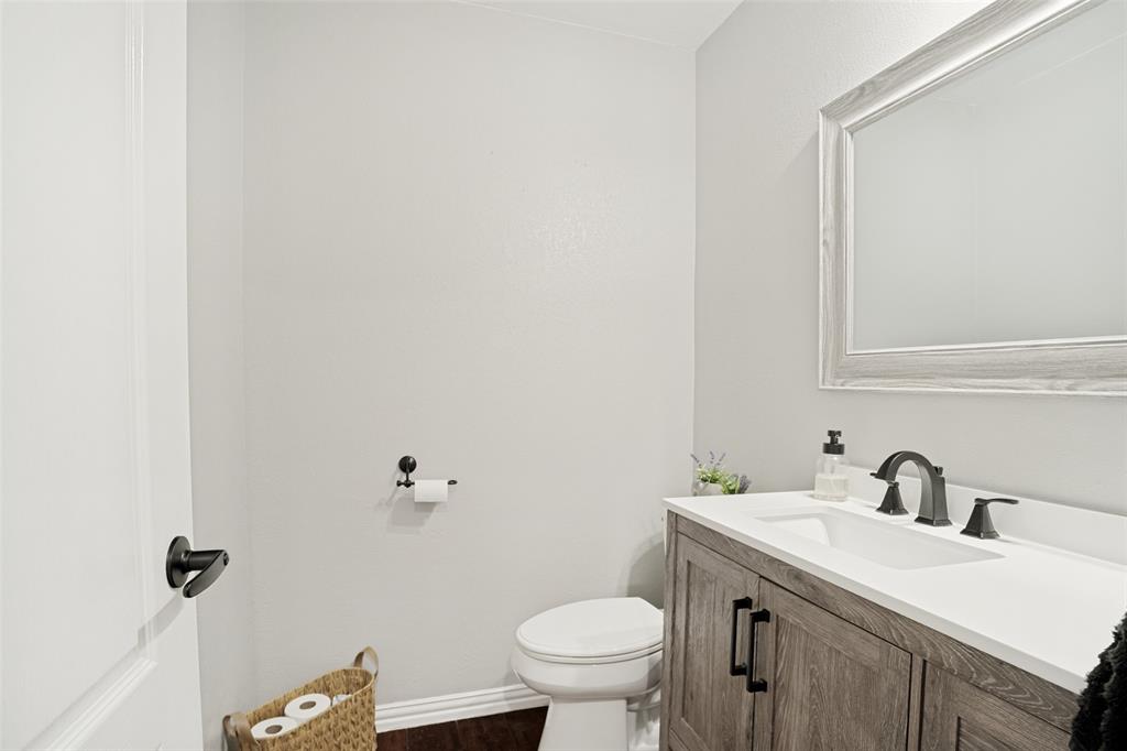 1612 Coventry Lane Allen, TX 75002 - Photo 15 of 39 Powder room featuring a wood-finish vanity with a white countertop and integrated sink