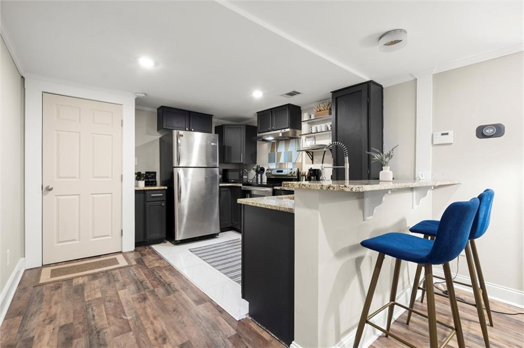 153 Randolph Street Northeast, Unit B Atlanta, GA 30312 - Photo 7 of 22 a kitchen with stainless steel appliances kitchen island granite countertop a refrigerator a stove a sink dishwasher with a dining table and chairs