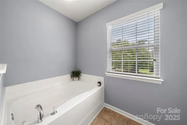 a white bath tub sitting in a bathroom next to a window