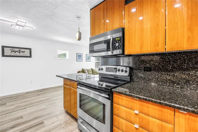 a kitchen with stainless steel appliances granite countertop a stove and a microwave