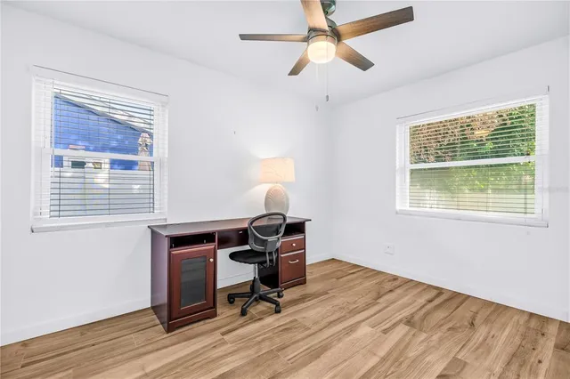 a view of a workspace with wooden floor and a window