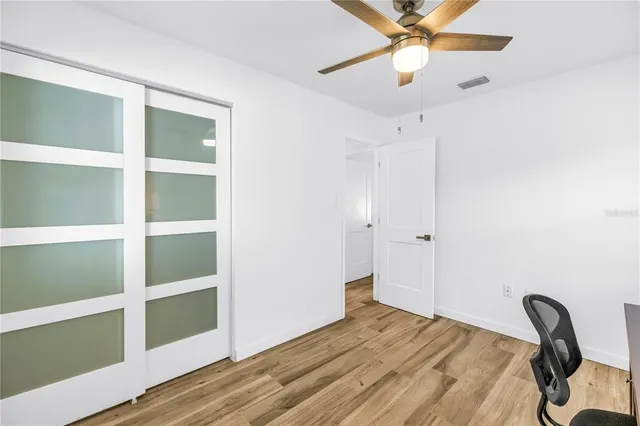 a bedroom with a bed and a chandelier fan