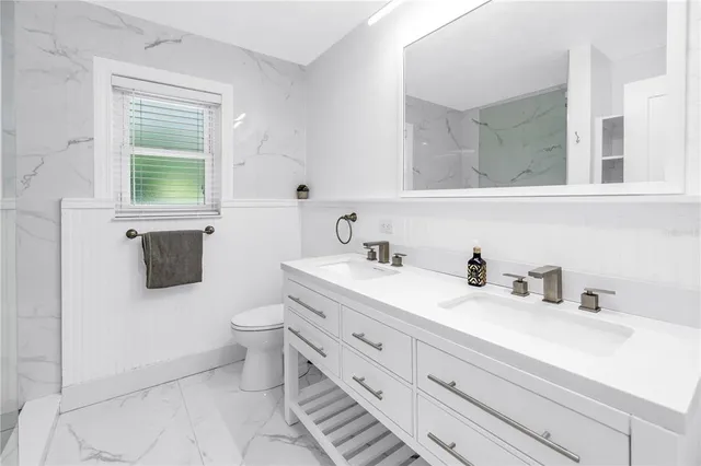 a bathroom with a toilet sink and mirror