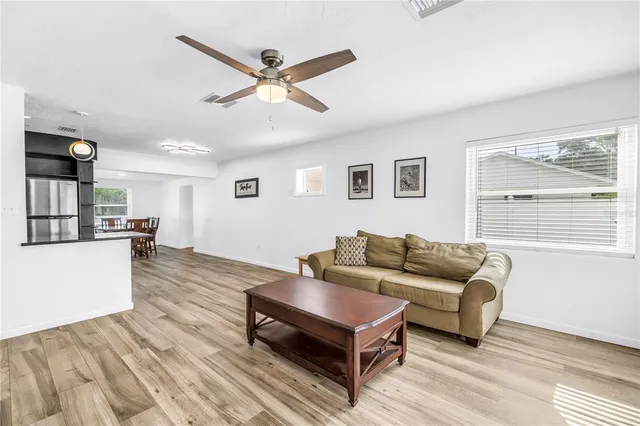 a living room with furniture and a wooden floor