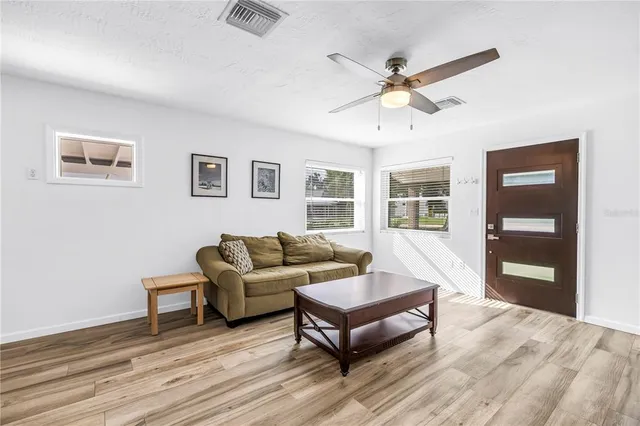 a living room with furniture and a ceiling fan