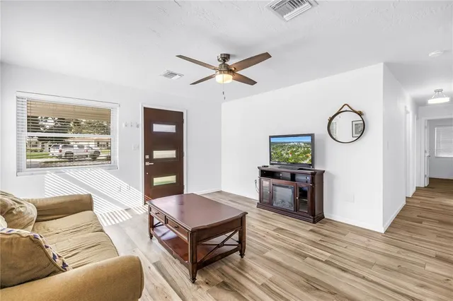 a living room with furniture and wooden floor
