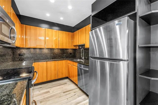 a kitchen with stainless steel appliances a refrigerator sink and cabinets