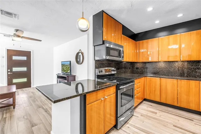 a kitchen with stainless steel appliances granite countertop sink stove and refrigerator