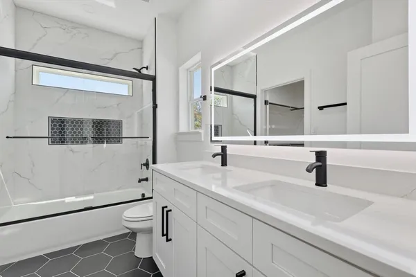 a bathroom with a sink a toilet and shower