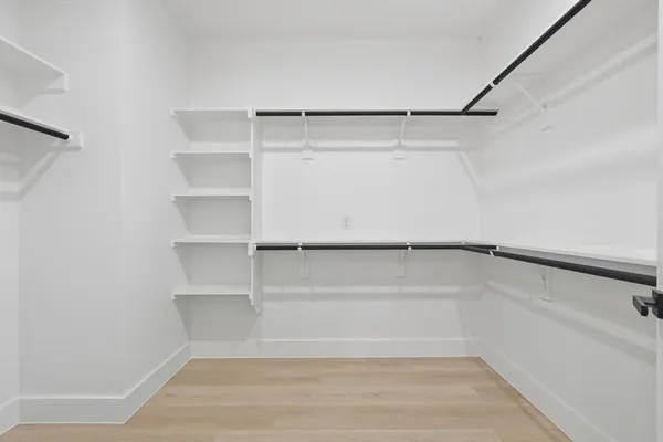 a view of walk in closet with empty racks