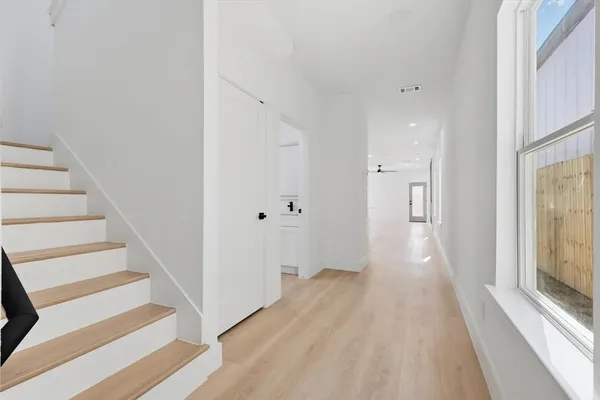a view of a hallway with wooden floor and entryway