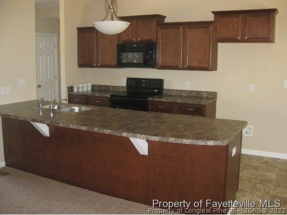 89 Jamestown Drive Spring Lake, NC 28390 - Photo 5 of 13 a kitchen with granite countertop a sink a stove and a wooden cabinets