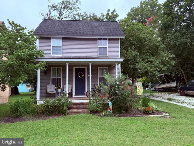 a front view of a house with a garden and plants