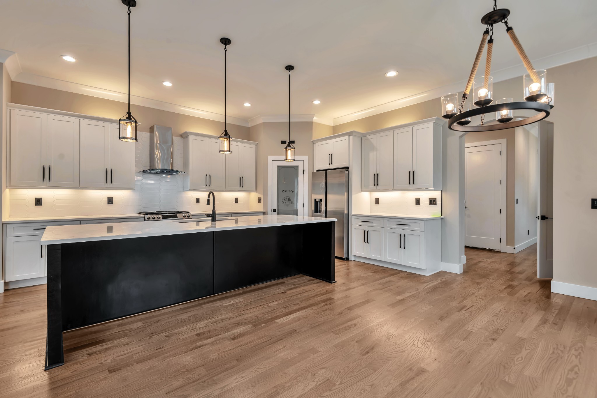 a room with stainless steel appliances kitchen island granite countertop a wooden floor