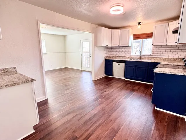 a kitchen with granite countertop wooden floors and wide window