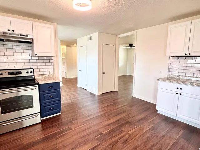 a kitchen with wooden floors and appliances