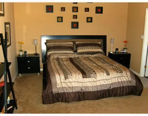 a bedroom with a bed and a night stand