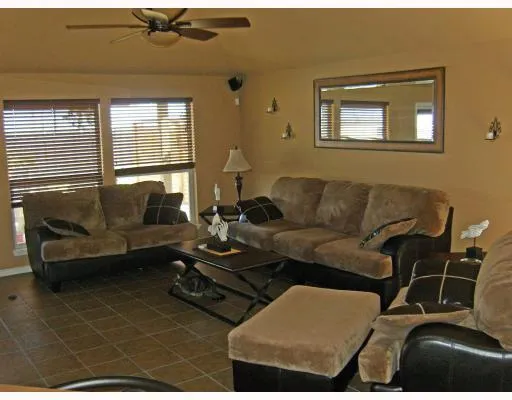 a living room with furniture a couch and two large window