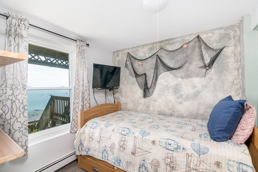 262 Manomet Point Road Plymouth, MA 02360 - Photo 15 of 40 a bedroom with a bed and a flat tv screen on the dresser