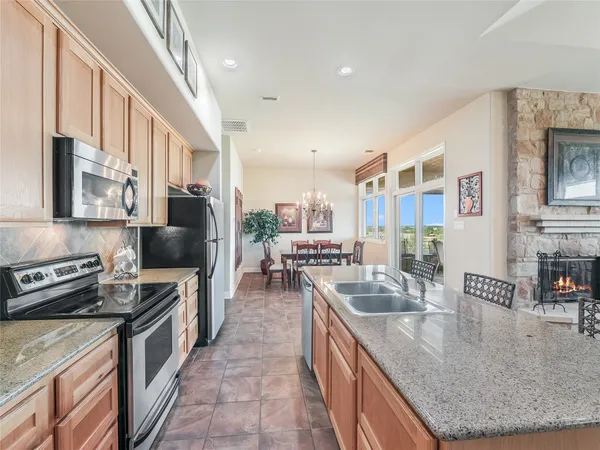 a large kitchen with stainless steel appliances granite countertop a lot of counter space and a sink