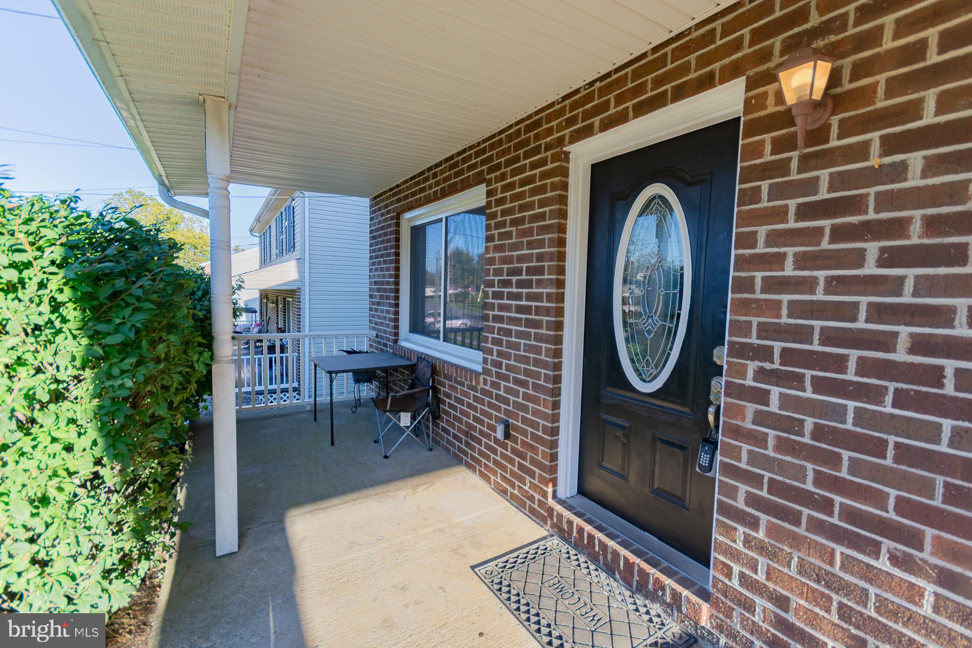 306 East 12th Avenue, Unit B Ranson, WV 25438 - Photo 2 of 31 a brick building with a bench and a potted plant