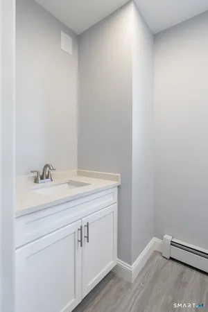 a kitchen with granite countertop white cabinets and wooden floor