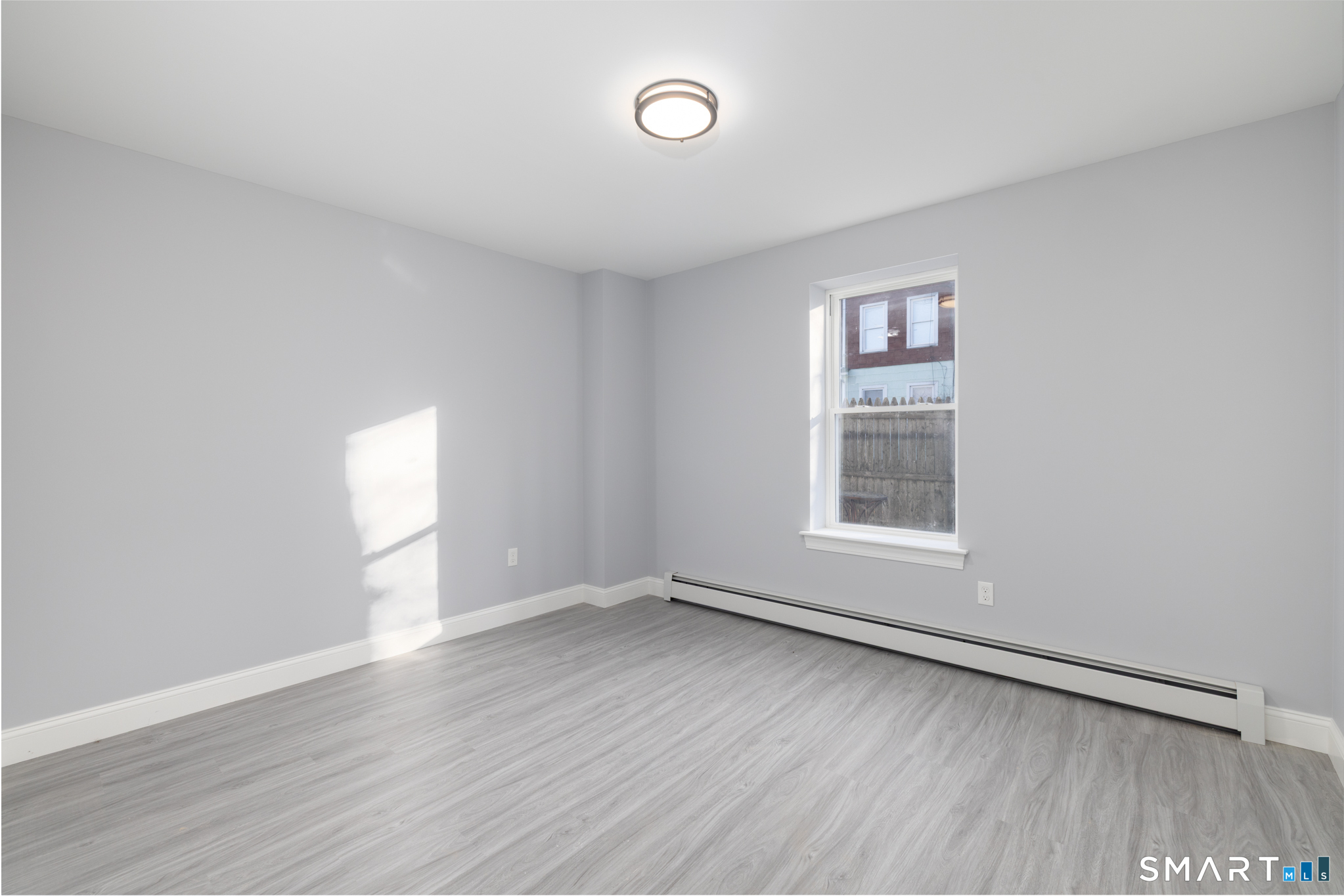 159 Park Street Bristol, CT 06010 - Photo 12 of 39 an empty room with wooden floor and windows