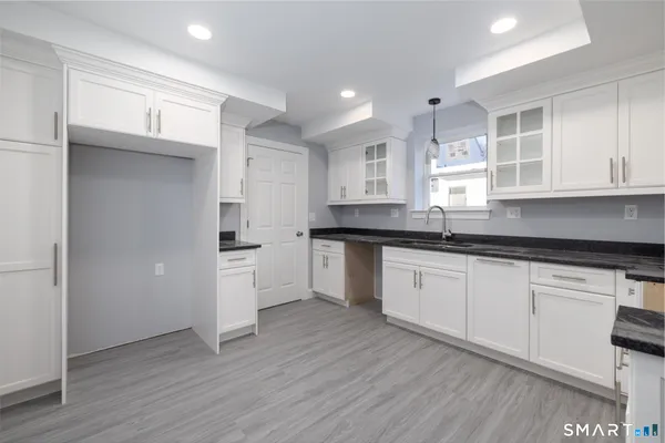 a kitchen with a refrigerator and white cabinets