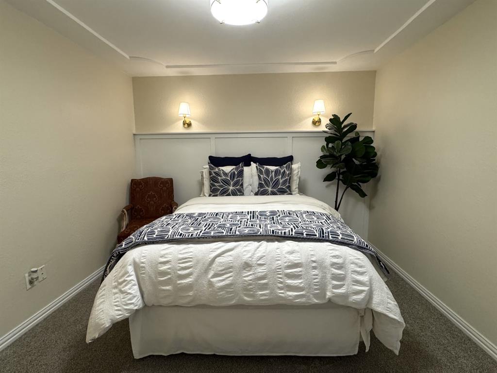 113 Northeast Timber Ridge Drive Burleson, TX 76028 - Photo 28 of 36 SPLIT Bedroom 2 featuring a paneled accent wall with integrated sconces, ceiling lighting, and crown molding