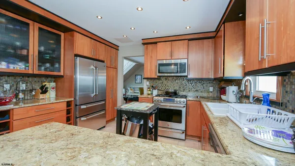 a kitchen with stainless steel appliances granite countertop a refrigerator sink and stove