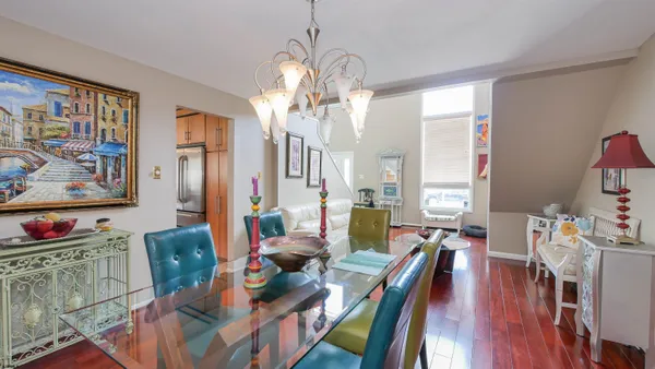 a view of a dining room with furniture a chandelier and wooden floor