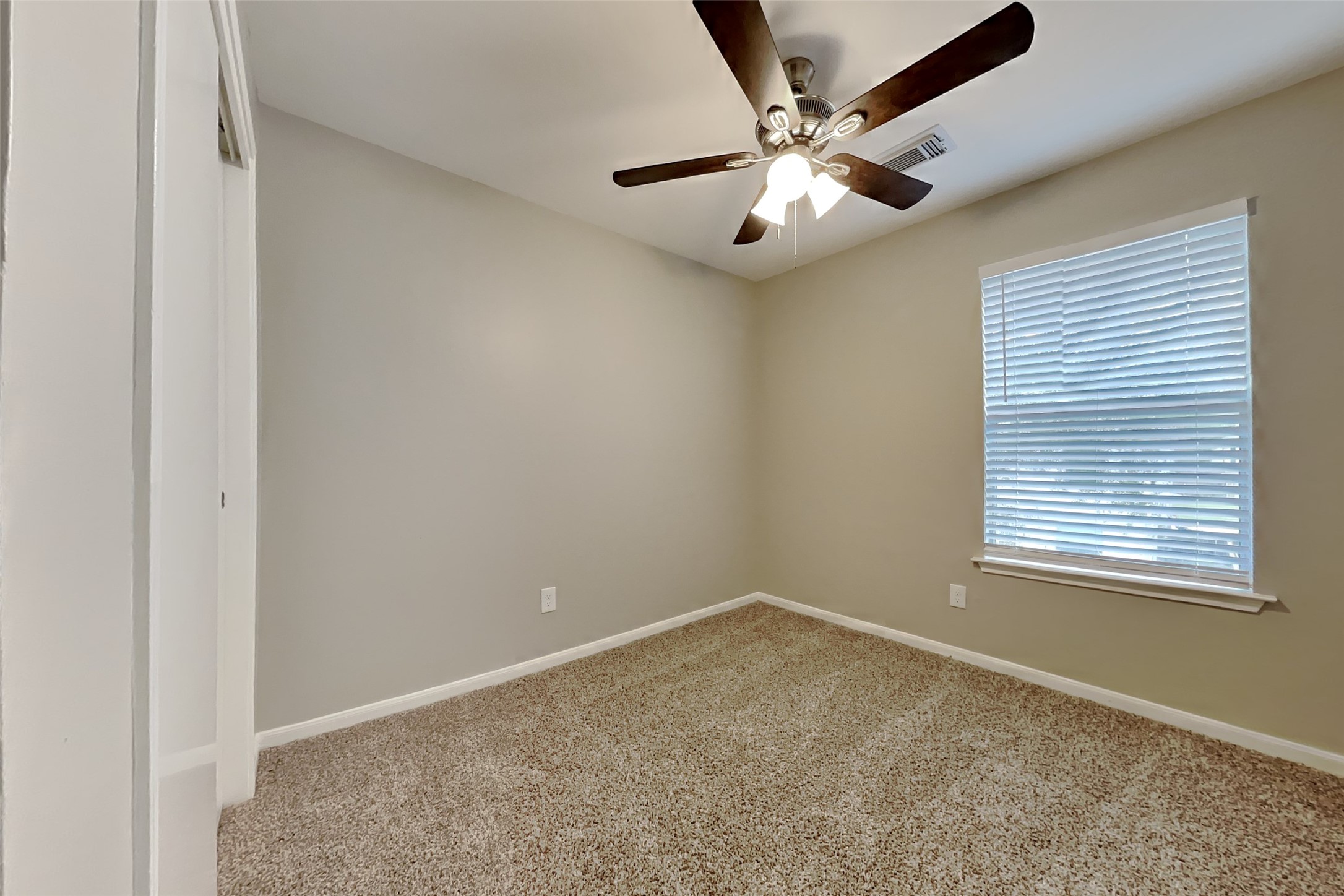 11802 Rolling Stream Drive Tomball, TX 77375 - Photo 14 of 19 an empty room with a chandelier fan and windows