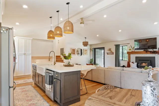 a large kitchen with stainless steel appliances kitchen island granite countertop a sink a stove and a refrigerator