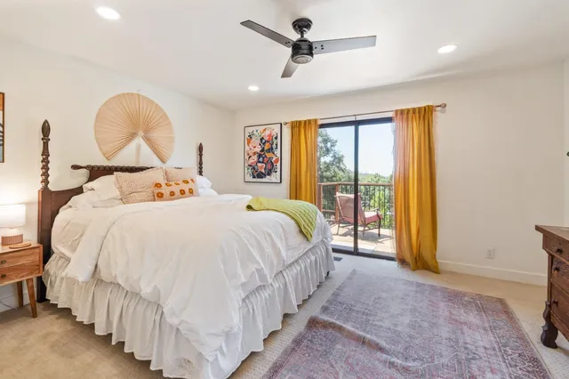 a bed sitting in a spacious bedroom next to a window