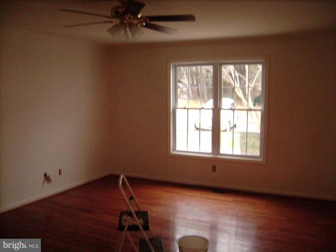 6024 Towles Mill Road Partlow, VA 22534 - Photo 6 of 11 an empty room with wooden floor fan and windows